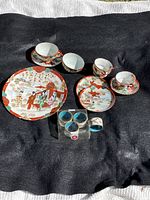 Photo shows 4 Imari style porcelain teacups with matching saucers, 2 decorative plates, and 4 cloisonné napkin rings in original box.