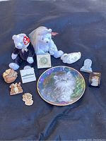 Overview photo of all mixed collectible items including cat plate, Ty Beanie Bears, Harmony Kingdom pieces, and QE2 memorabilia.