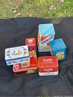 Photo showing 6 vintage cookie or cracker tins with Campbell's and Nestle branding and decorative designs
