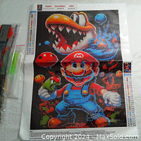 Mario-themed 5D diamond painting canvas showing pixelated image of Mario and game characters with diamond beads applied.