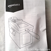 Illustrated manual showing Amazon Basics deep fryer with fry basket and handle, lid with viewing window, and temperature control knob.