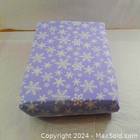 Folded fitted sheet showing white snowflake pattern on light blue cotton flannel fabric