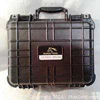 Top view of black hard shell camera case with ribbed design, handle, and Matou Xing label.