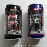 Both mini remote control cars inside pop can-shaped plastic packaging, viewed from above