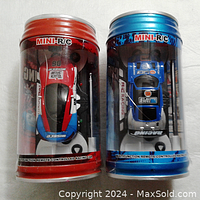Two mini R/C pop can racers in their original packaging, showing front view inside clear plastic