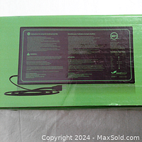 Top view of the green Seedfactor heat mat with instructions and certification label