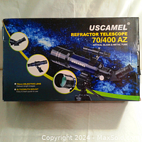 Packaging box featuring product details and images of the refractor telescope and its components.