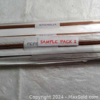 Close-up image showing individual incense sticks with paper labels indicating scents such as Magnolia, Peppermint, and a label stating 'Sample Pack 2'. The sticks are of standard size and unopened.