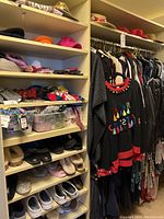 Overall closet view showing women's clothing on hangers, hats on top shelves, and shelves filled with shoes and small accessories.