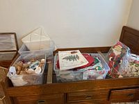 Wide view of storage bins with holiday cloth items and basket pieces placed on a wooden frame.