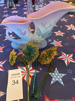 Overall view of the double cornucopia vase with three blown glass magnolia flowers placed in front.