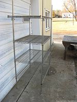 Side angle of four-shelf wire rack showing height and depth.