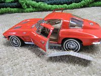 Close-up of red 1963 Corvette metal model car with driver side door open showing detail