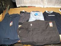 Photo of cold weather clothing items laid out including North Face vest and jacket, Cabela's base layer pants, Columbia pants, Volcom shirt, all with tags.