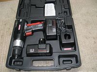 Black Craftsman drill driver with silver chuck, red trigger, two 16.8V batteries, charger, all arranged inside original black molded plastic carrying case.