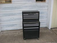 Front view of Craftsman bottom rolling tool chest with six-drawer top box in front of metal garage door