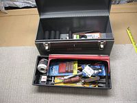 Open metal Craftsman toolbox showing partial set of black deep impact sockets, test light, and various hand tools in red tray.