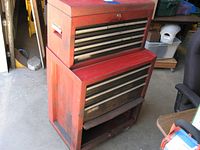 Overall view of red Craftsman toolchest and top box stacked together, showing wear and one stuck open lower door.