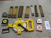 Wooden folding rulers and various measuring tapes on carpet