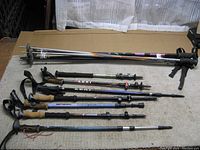 Seven hiking and trekking poles laid out flat showing grips, straps, and locking mechanisms
