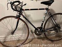 Side view of entire bicycle leaning against wall