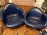 Front view of both chairs showing navy blue vinyl upholstery and overall condition