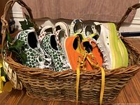 Overview of assorted women's Converse shoes jacketed in a woven basket showing multiple pairs including unique designs and solid colors.