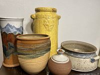 Five hand glazed stoneware items grouped on a surface showing colors and forms