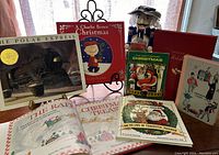 Vintage Christmas books arranged with wooden nutcracker figure and numbered blocks for Advent calendar on a table near window light.
