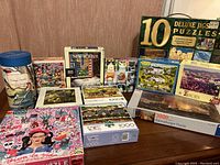 Overall view of multiple puzzle boxes arranged on table showing different designs and piece counts