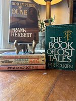 Books stacked with God Emperor of Dune and The Book of Lost Tales prominently visible