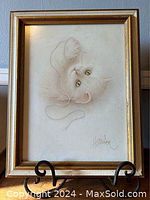 Framed print of white cat playing with string, gold-tone frame around 11.5 x 14.5 inches, signed Bob Harrison bottom right.