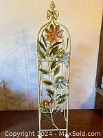 Full view of the vintage French toleware wrought iron wine rack with floral decorations.