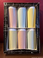 Top-down view of six insulated tumblers in original box, arranged in two rows of three with pastel colors.