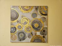 Full front view of the canvas artwork showing abstract circles and gold details.
