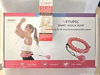 Photo showing the boxed Vetupic smart hula-hoop along with Elaimei Slim Cream box placed on top.