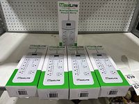 Five new MaxLite energy saving power strips in original packaging arranged on a shelf.