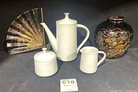 Photo showing all items: white porcelain Noritake Snowville tea pot, creamer, sugar bowl, black Imperial Kiku vase with floral bird design, and decorative fan with gold and black pattern