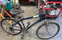 Full side view of the Cannondale Comfort bike showing dark blue frame, saddle, tires, pedals, and handlebar.