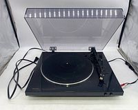 Full view of Denon DP-300F turntable with dust cover open, power cord and audio cables visible.