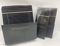 Set components including folded black duvet cover and two boxed pillow shams with Donna Karan branding.