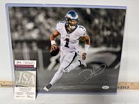 Photo of signed Jalen Hurts action photo with autograph and photo certificate on display