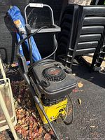 Full side view of the Karcher pressure washer with yellow base and black Briggs & Stratton engine, hose attached, and wand stored on side