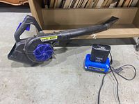 Full view of Kobalt leaf blower lying on floor next to battery and charger.