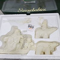 Set of three Snowbabies figurines in original Styrofoam packaging inside box, wrapped in clear protective plastic.