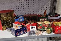 Overview of various tins and boxes with Christmas ornaments and clips displayed on a shelf