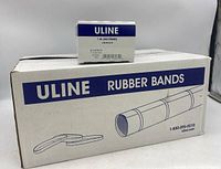 Large white box containing 10 smaller boxes of Uline rubber bands, with one box displayed on top showing Uline branding and size details.