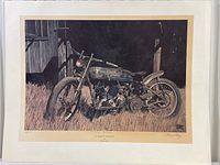 Frontal image of print showing vintage Harley motorcycle by Bruce Lattig, set outdoors with detailed grass and building textures.