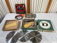 Overall lot showing various blades and dado accessory boxes spread on table
