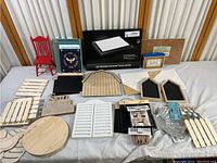 Full overview of all crafting items on a white cloth including wooden pieces, light box, chalkboards, red miniature chair, and books.